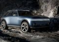 A matte blue Genesis X Gran Equator Off-Road Concept SUV with roof racks and large off-road tires is parked on rocky terrain.