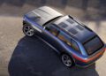 A metallic blue Genesis X Gran Equator SUV with a panoramic roof and modern design is parked on a sunlit concrete surface, viewed from above at an angle.