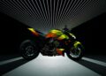 A neon yellow and black Ducati motorcycle is displayed under converging white light beams against a dark background, echoing the sleek innovation showcased at Milan Design Week 2025.