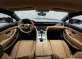 Luxury car interior featuring tan leather seats, diamond-patterned upholstery, a digital dashboard, and a central control panel with metallic and black accents.