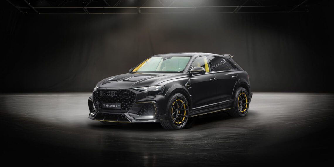 A black Audi SUV with yellow accents is parked on a smooth surface under dramatic studio lighting against a dark background.
