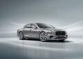 The Bentley Continental GT luxury sedan is displayed on a smooth gray background, showcasing its sleek design and elegant features.