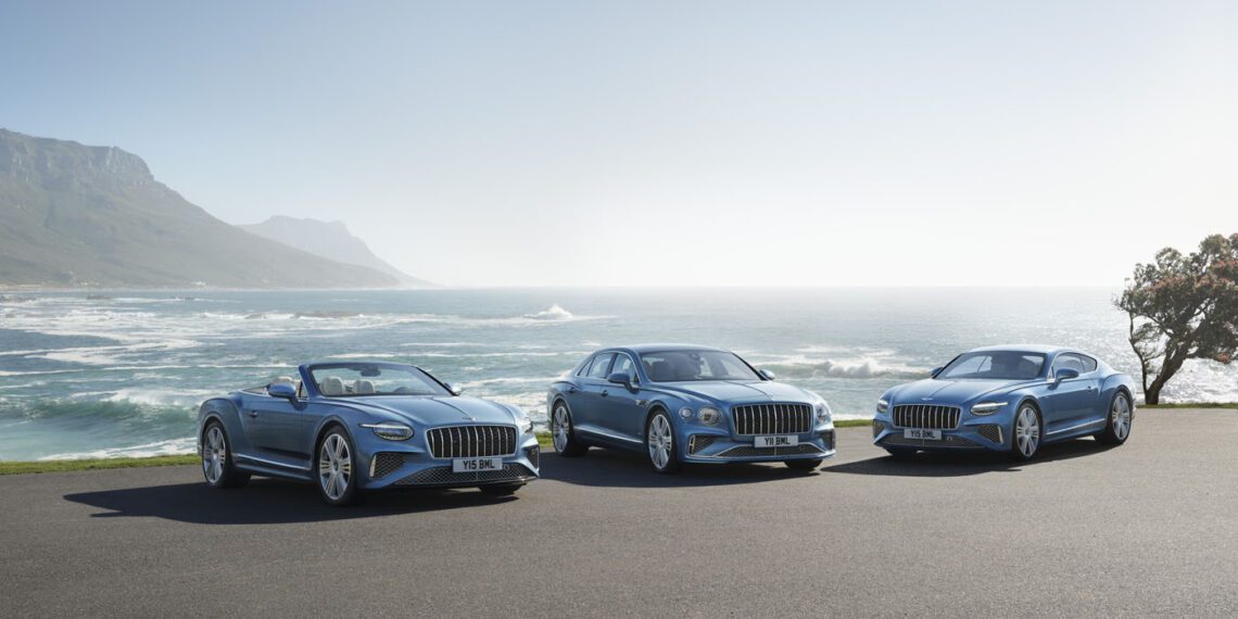 Three blue luxury cars, including a Bentley Continental GT, are elegantly parked on a coastal road. With an ocean backdrop and mountains in the distance, their combined 671HP offers a perfect blend of power and scenic beauty.