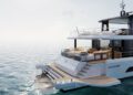 A modern white Arcadia Yachts A80new with multiple decks and outdoor seating is anchored on calm, open water under a clear sky, showcasing a commitment to sustainability.