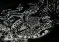 A detailed embroidery of a lion and unicorn crest is being stitched by a sewing machine, reminiscent of the elegance seen in the Royal Warrant awarded to Aston Martin.