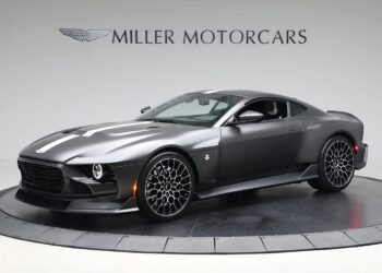 A 2024 Aston Martin Valour in Xenon Grey Metallic is displayed in a showroom with "Miller Motorcars" branding on the wall behind it.