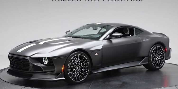 A 2024 Aston Martin Valour in Xenon Grey Metallic is displayed in a showroom with "Miller Motorcars" branding on the wall behind it.