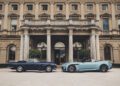 A classic convertible and a modern Aston Martin parked side by side in front of a large, elegant building with tall columns, exuding an air worthy of a Royal Warrant.