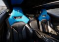 Interior view of a modern sports car featuring two black and blue bucket seats, a center console, and minimalistic dashboard controls, designed in collaboration with Magnus Walker for Automobili Pininfarina.