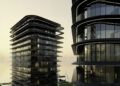 Two modern high-rise buildings with curved, layered exteriors stand near the Abu Dhabi waterfront at sunset, with a road, car, and docked yacht visible below—an impressive showcase of luxury real estate.