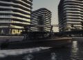 A modern motorboat glides through water at dusk before sleek, curved high-rise buildings, reflecting the allure of Abu Dhabi’s luxury real estate.
