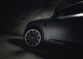 Close-up of a BRABUS-tuned car's front wheel and side, partially illuminated in a dimly lit environment, hinting at the raw power of its 637HP engine.