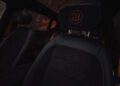 Close-up of a black car seat interior with orange stitching, showcasing BRABUS sophistication. The headrest, featuring the letter "B" embroidered in vibrant orange, hints at the car's impressive 637HP under the hood.