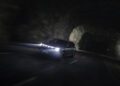 A sleek BRABUS car with illuminated headlights glides through a dimly lit tunnel on a roadway at night, harnessing its impressive 637HP for an effortlessly powerful drive.