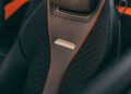 Close-up of a car seat with diamond-patterned black upholstery, orange accents, and a metallic "Daytona" badge on the backrest, reminiscent of the luxury found in a Bentley Batur Convertible seen in Dubai.