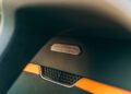 Close-up of a Bentley Batur Convertible interior detail showing a badge labeled "BATUR, COACHBUILT BY MULLINER" above an orange accent and black mesh compartment, evoking the luxury seen in Dubai's finest vehicles.