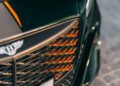 Close-up of the front grille of a Bentley Batur Convertible with orange accents and a prominent Bentley emblem, captured during its public debut in Dubai.