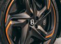 Close-up of a Bentley Batur Convertible wheel in Dubai, featuring a black alloy rim with orange accents and the Bentley logo at its center during its public debut.