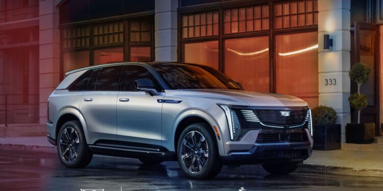 A silver SUV is parked on a city street in front of an illuminated building. Logos for Cadillac, Cote, La Dolce Vita, and others are displayed at the bottom of the image.