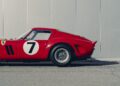 Side view of a classic red Ferrari 250 GTO sports car with the number 7 on the door, parked on pavement in front of a plain light-colored wall—an icon often seen at Cavallino Classic events.