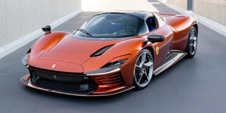 A sleek, orange Ferrari sports car with a modern design is parked on a paved surface, surrounded by the luxury of Beverly Hills' urban architecture and greenery.