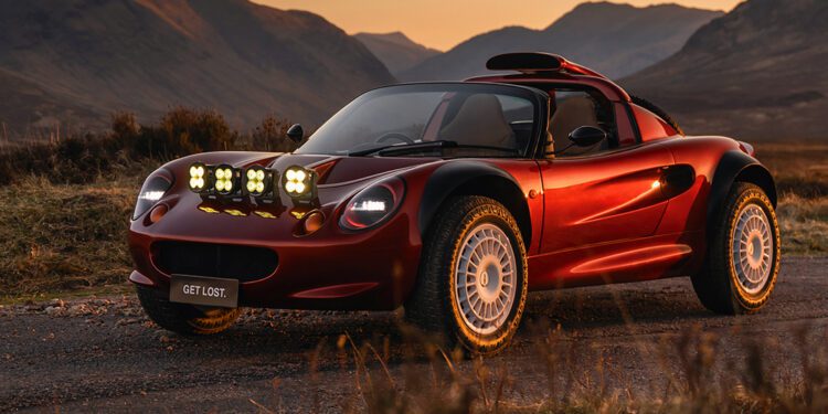 A red sports car with off-road tires and extra lights on the hood is parked on a rural road at sunset. The license plate reads "GET LOST." Mountains are visible in the background.