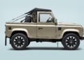 A beige two-door Defender Soft Top off-road vehicle with a soft top roof, shown in side profile against a light blue background.