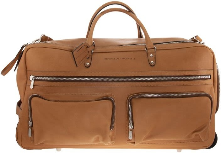 A large tan leather duffel bag with two front zippered pockets, silver hardware, top handles, and a luggage tag—perfect for a style upgrade or as one of your essential luxury accessories.