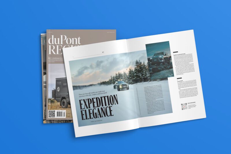 A magazine spread featuring cars driving through snow-covered trees under the headline "Expedition Elegance" from duPont REGISTRY's No. 480 issue, May 2025. Closed magazines rest beneath on a blue background, capturing the allure of luxury and adventure in every page.