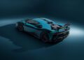 A teal Ferrari SF90 XX Stradale by NOVITEC, featuring customizations like a large rear wing and black accents, is parked in a dimly lit studio, viewed from the rear three-quarter angle.