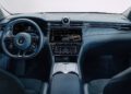 Interior view of a Maserati's luxury dashboard, featuring a digital display, steering wheel with logo, and central console adorned with buttons and dials—all showcasing a sleek, modern design reminiscent of innovations unveiled at Milan Design Week.
