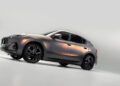 A metallic gray SUV, embodying Maserati's elegance, is displayed at an angle against a white background, highlighting its sleek design and black wheels.