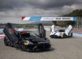 Two sports cars with open scissor doors are parked on the racetrack at Circuit Paul Ricard. One, a Maserati GT2 Stradale, is labeled as a safety car, setting the scene for an exhilarating event in the GT World Challenge Europe.