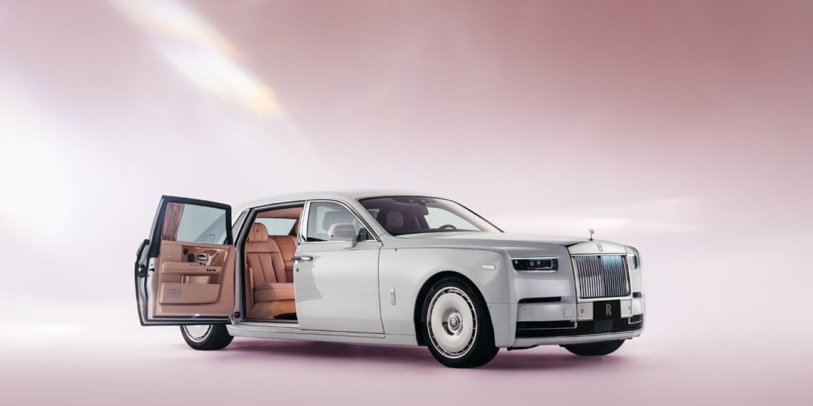 Luxury car with a white exterior, open passenger door, and tan leather interior, displayed against a soft pink background.