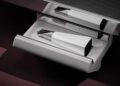 A modern, geometric white and silver object—resembling a bespoke chess set—rests inside a sleek open drawer beneath a reflective surface, evoking the refined elegance of ultra-luxury design.