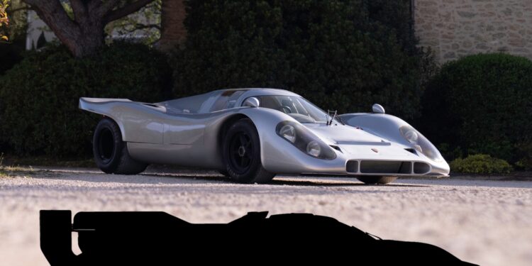 A vintage silver race car, reminiscent of a street-legal 917, is parked on a gravel driveway, with trees and a stone building in the background. The silhouette of a sports car celebrates Porsche 50 years at the bottom of the image.