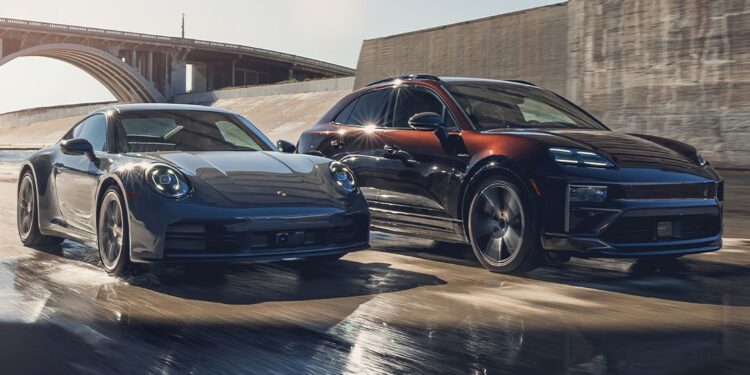 A Porsche sports coupe and an SUV drive side by side on a wet road beside a bridge, reflecting sunlight.