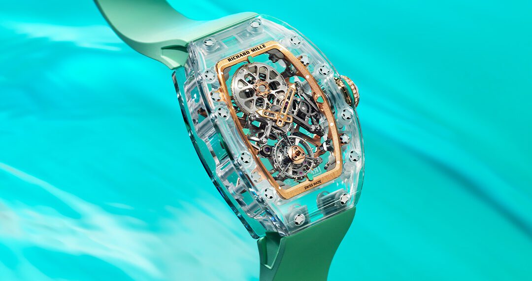 A close-up of a transparent Richard Mille RM 75-01 mechanical wristwatch with a green strap, floating above a turquoise water background—part of the stunning Sapphire Collection.