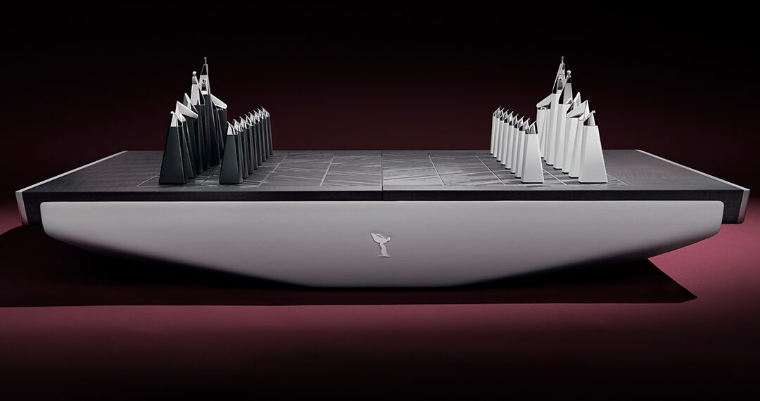 A bespoke chess set featuring abstract, angular black and white pieces on a minimalist rectangular board, viewed from the side against a dark background—an ultra-luxury design reminiscent of Rolls-Royce sophistication.