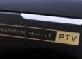A close-up of a vehicle panel with a label that reads "PROTOTYPE VEHICLE PTV" in gold text on a black background, hinting at the remarkable 300 mile range of this future electric SUV.