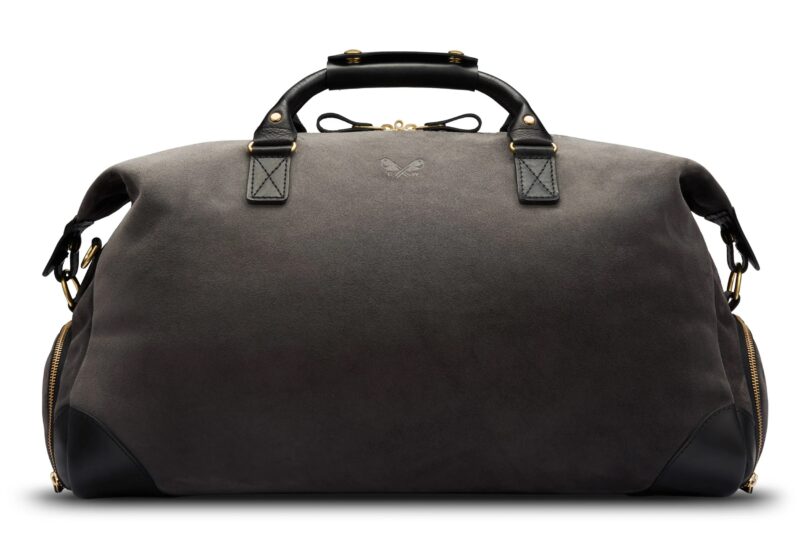 A large, dark grey duffel bag with black leather handles and accents, gold hardware, and a small embossed logo on the front—a perfect style upgrade for those seeking luxury accessories.