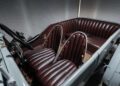 Vintage Bentley car interior featuring Heritage Leather dark brown seats, wooden flooring, and a simple dashboard, viewed from the driver's side.