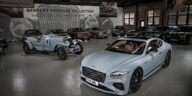 A modern Bentley coupe featuring Heritage Leather as an interior option stands beside a vintage Bentley, both displayed in a showroom with other classic vehicles and Bentley Heritage Collection signage in the background.