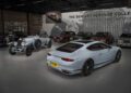 A modern Bentley coupe with Heritage Leather interior option and a vintage Bentley are displayed among other classic vehicles in the Bentley Heritage Collection showroom.