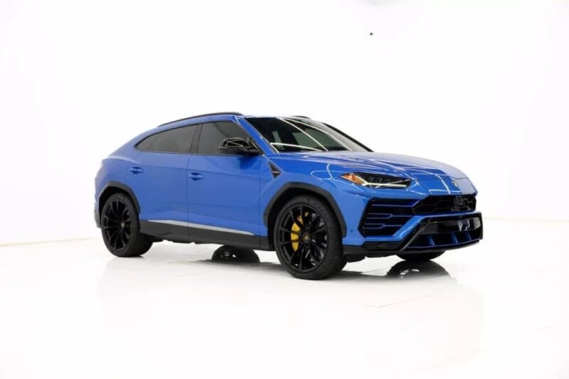A blue luxury SUV with black wheels and tinted windows, this exotic car is parked in a white studio setting—an exceptional car for sale that exudes style and sophistication.