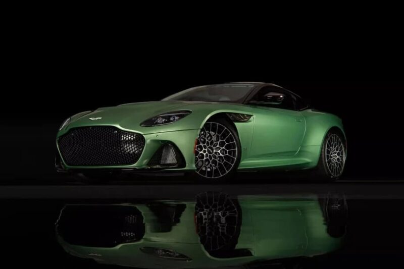 A luxury car for sale, this green sports car is displayed against a black background, its stunning reflection shimmering on the glossy surface below.