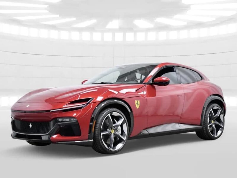 A red Ferrari Purosangue SUV is parked in a modern, white indoor setting with bright overhead lighting.
