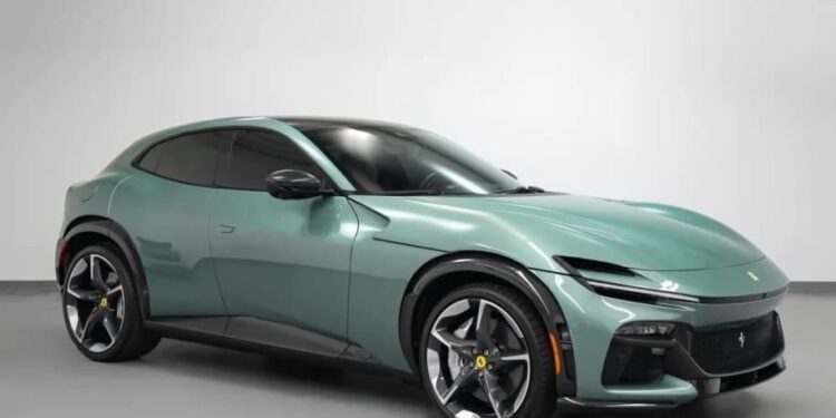 A metallic green Ferrari Purosangue SUV is parked in a plain indoor setting, viewed from the front left angle.