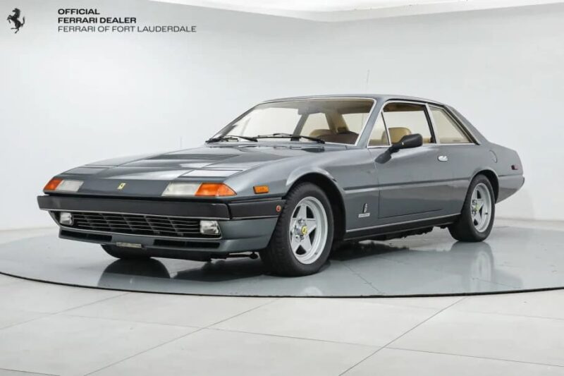A classic gray Ferrari coupe, this exotic car features a light interior and alloy wheels, showcased at Ferrari of Fort Lauderdale.