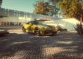 A yellow Porsche 911 Spirit 70, a limited edition Porsche with the number 70 on its side, is parked on a cobblestone driveway in front of a modern white house surrounded by trees.